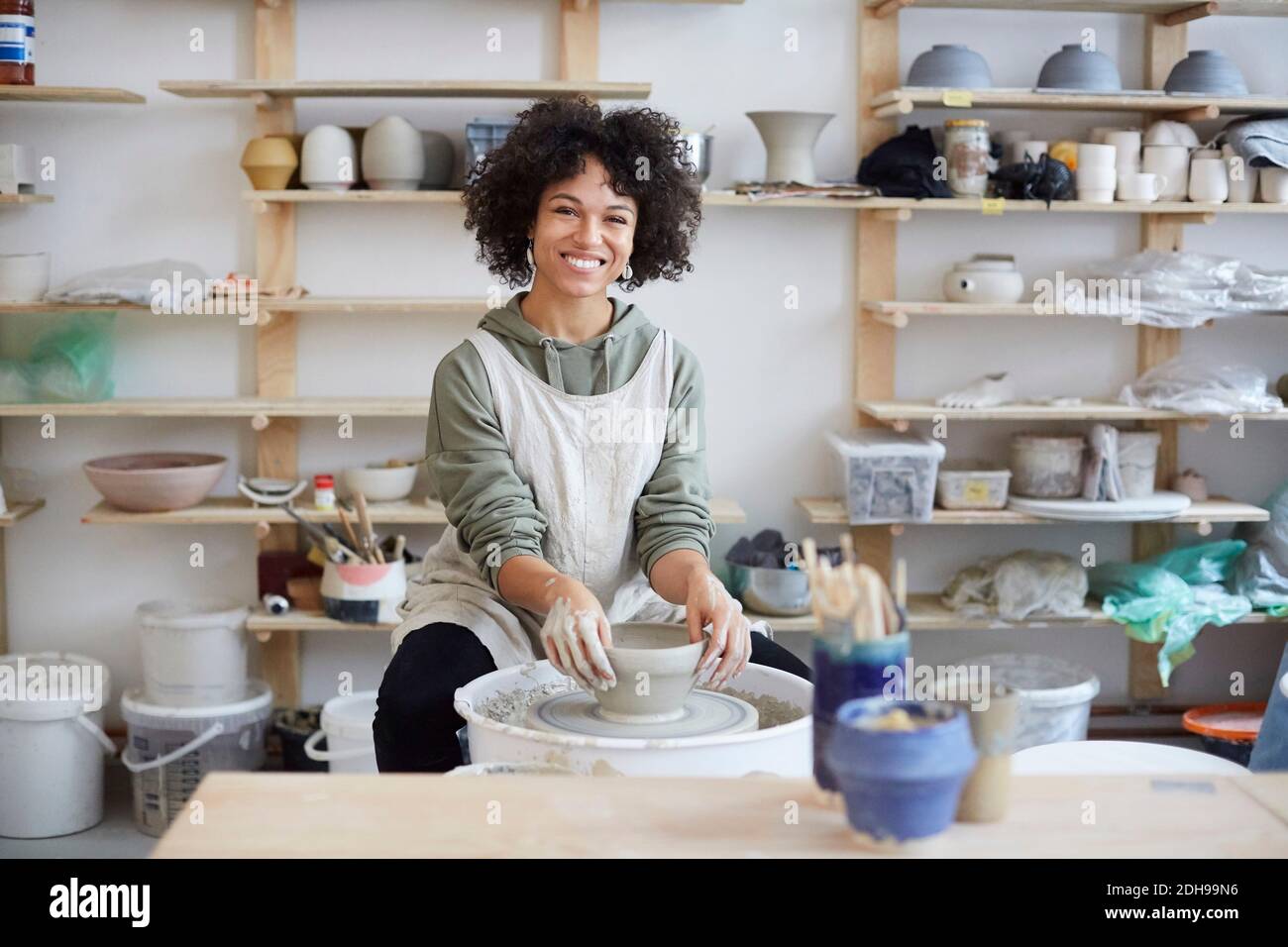 Portrait of smiling woman learning pottery in art studio Stock Photo