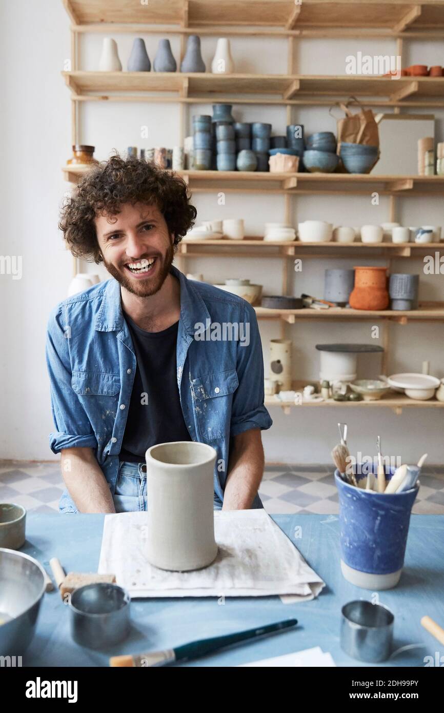 Portrait of smiling man sitting in pottery class Stock Photo