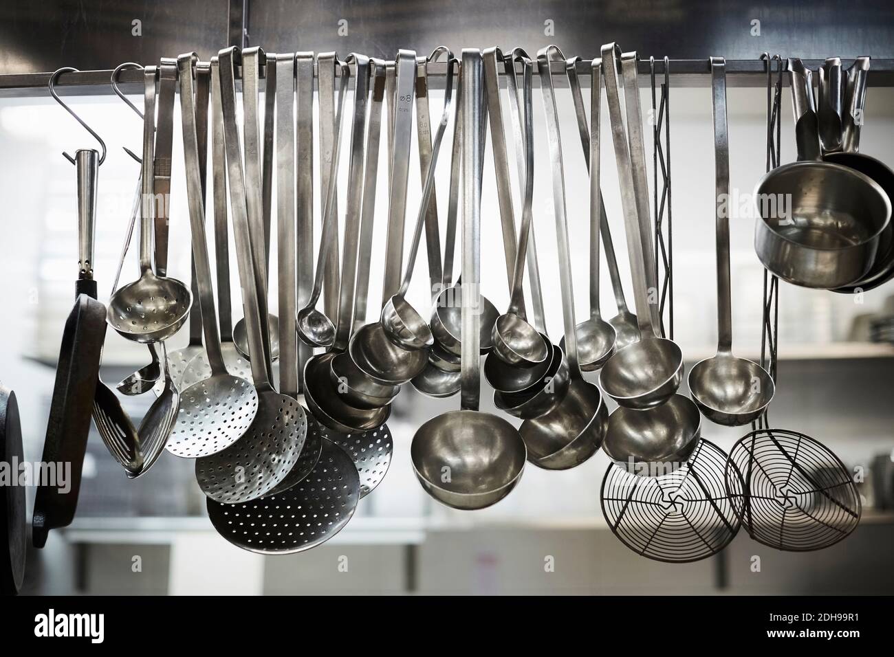 Utensils on metal rack in commercial kitchen Stock Photo