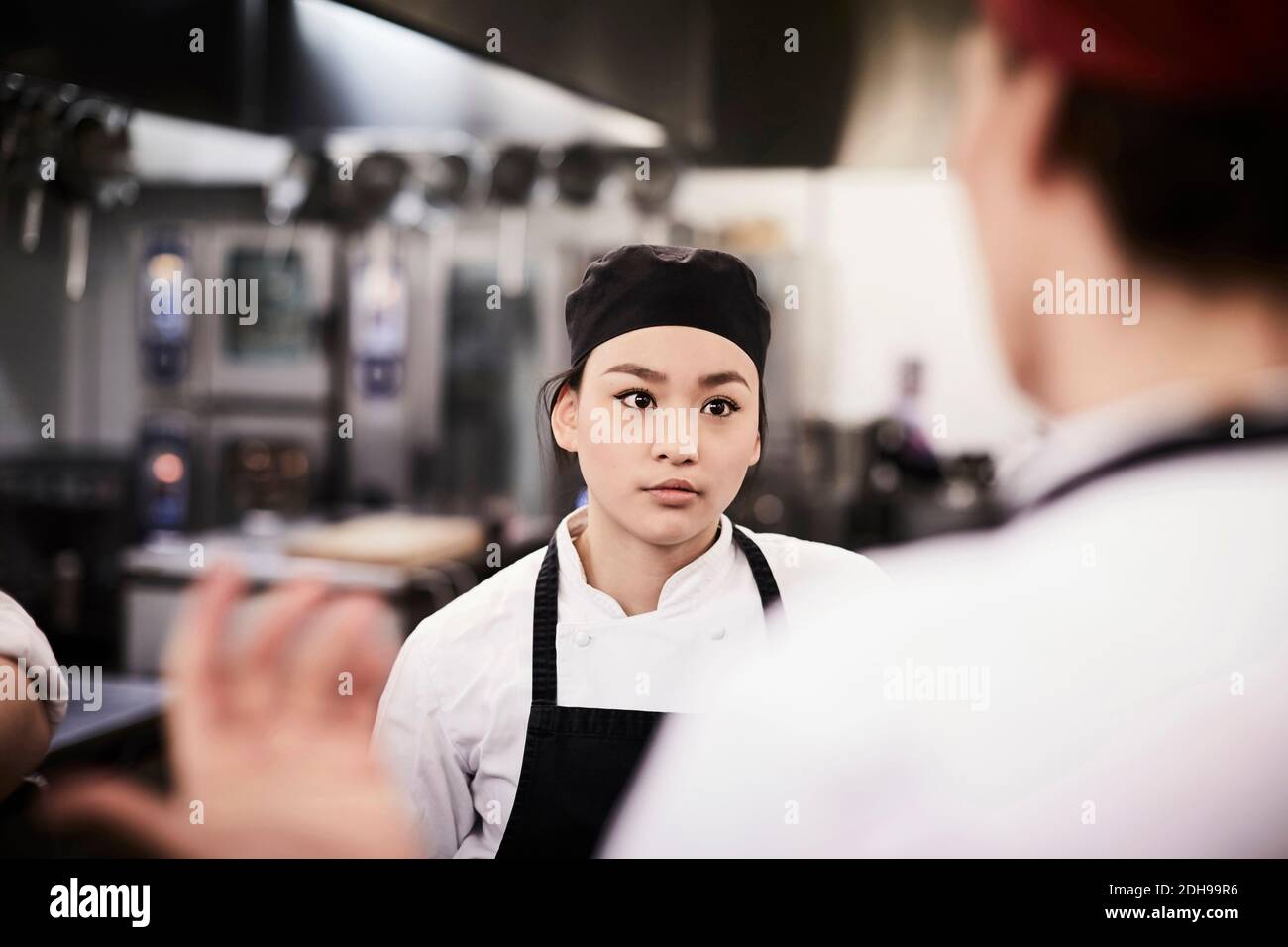 Female chef student listening to teacher in cooking school Stock Photo