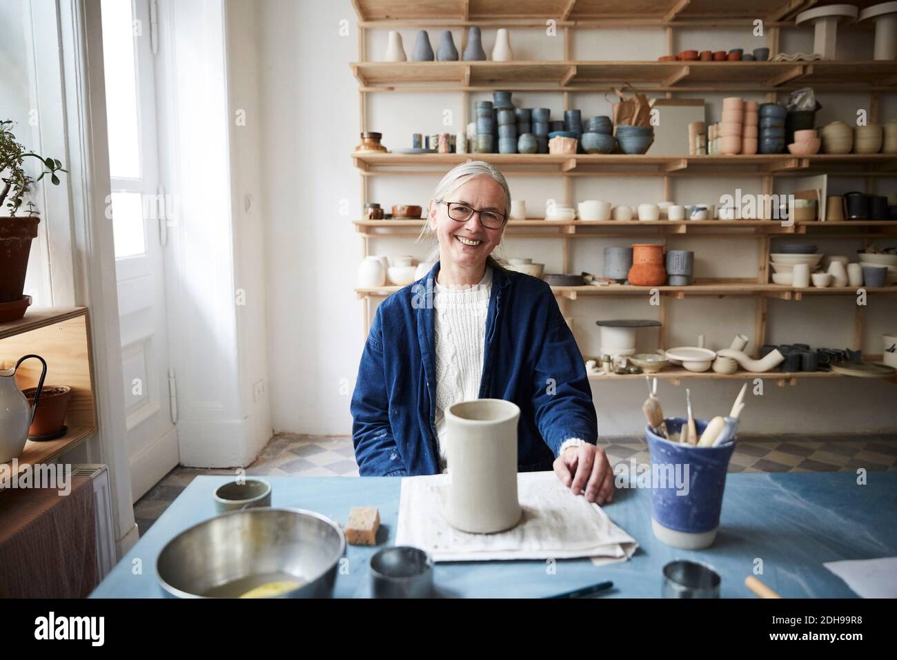Portrait of smiling mature woman sitting in art class Stock Photo