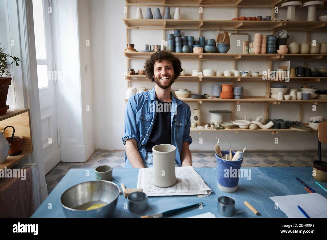 Portrait of smiling man sitting in pottery class Stock Photo