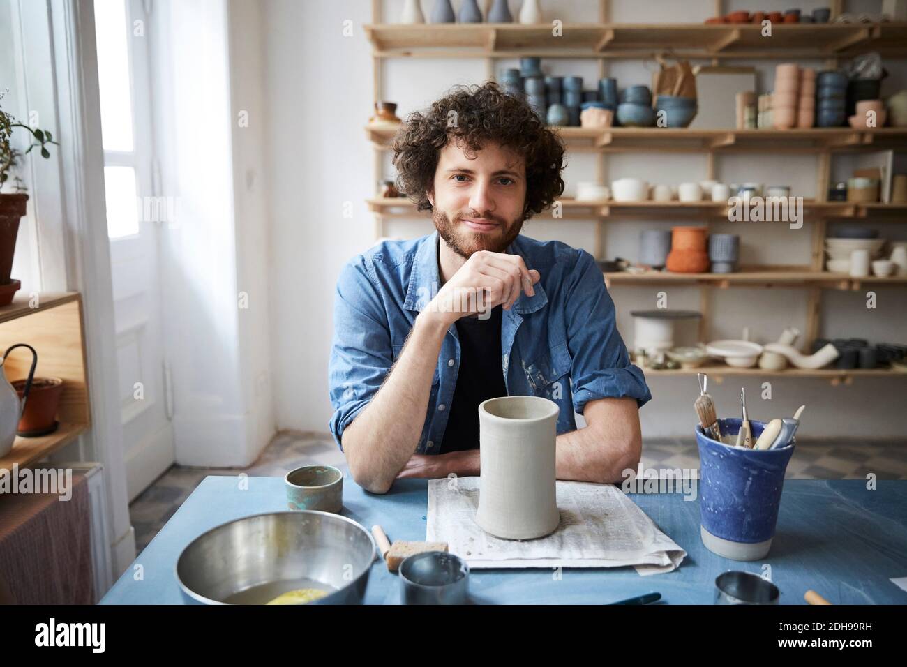 Portrait of mid adult man sitting in pottery class Stock Photo