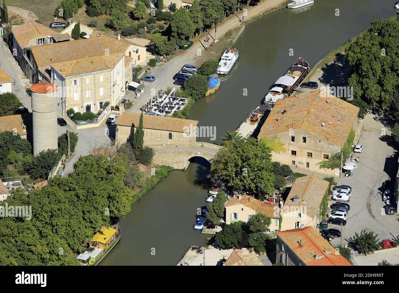 Aude department (south of France): aerial view of the harbour of Somail and its old stone bridge across the ÒCanal du MidiÓ, in summer. This hamlet, r Stock Photo