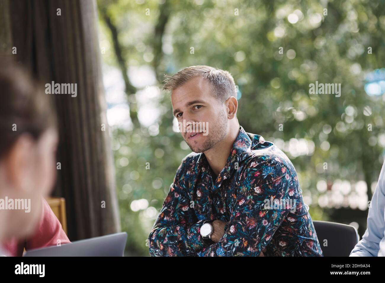 Confident businessman looking at colleague during meeting in portable office truck Stock Photo
