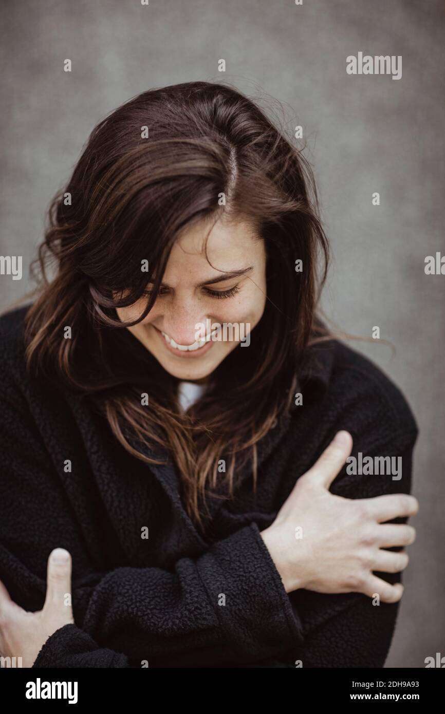 Happy woman with eyes closed standing outdoors Stock Photo