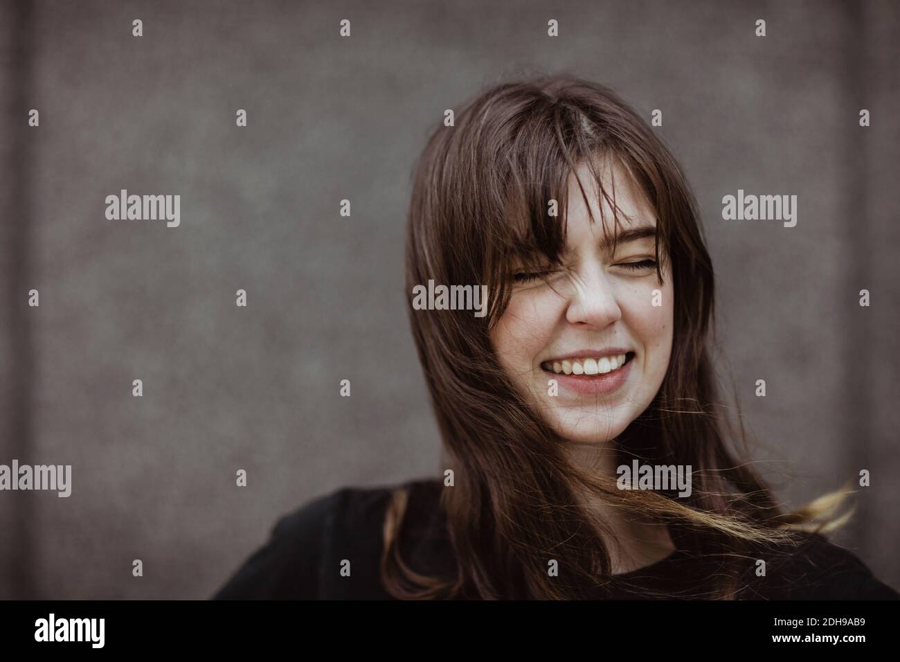 Happy woman with eyes closed standing outdoors Stock Photo