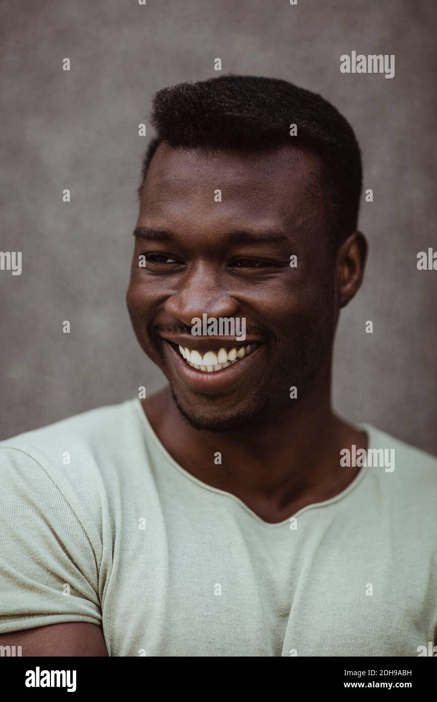 Close-up of happy man looking away while standing outdoors Stock Photo
