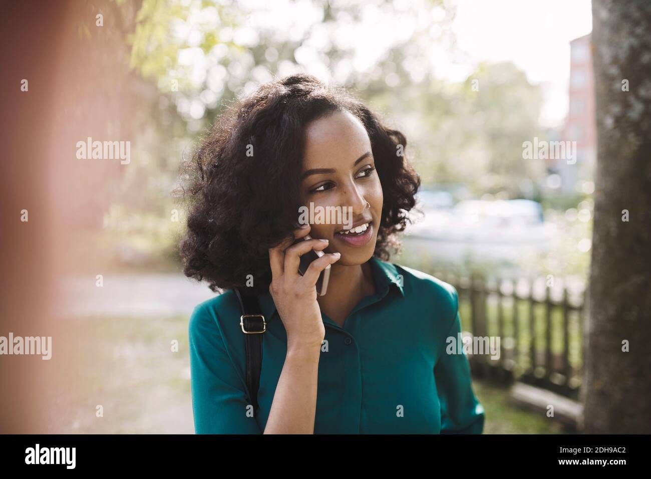 Businesswoman using smart phone at park Stock Photo