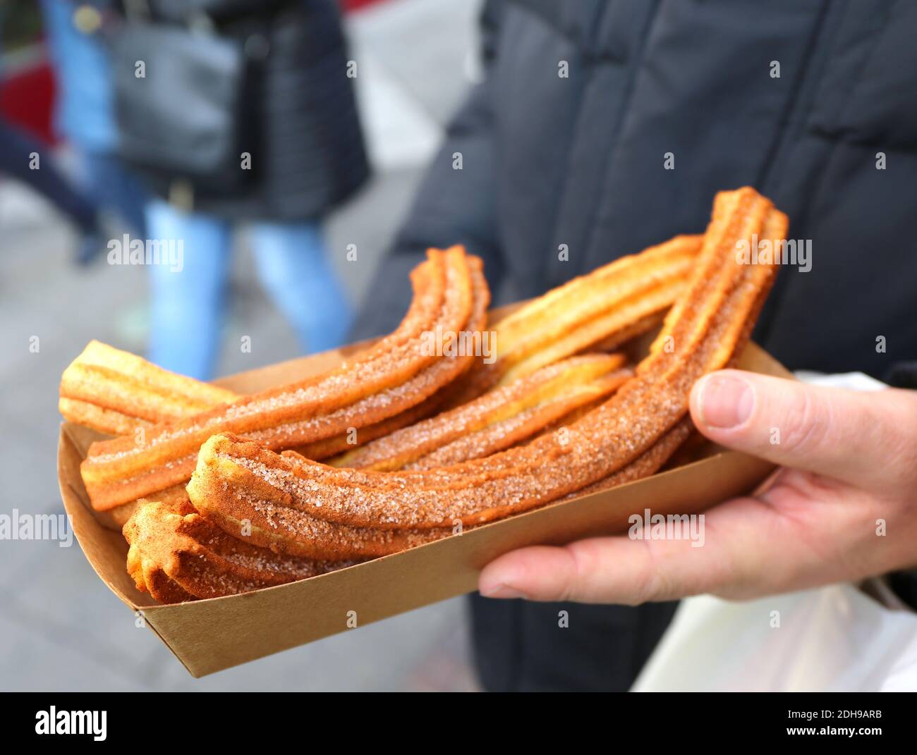 Hand Holding Spanish Churros with Cinnamon and Sugar at Christmas