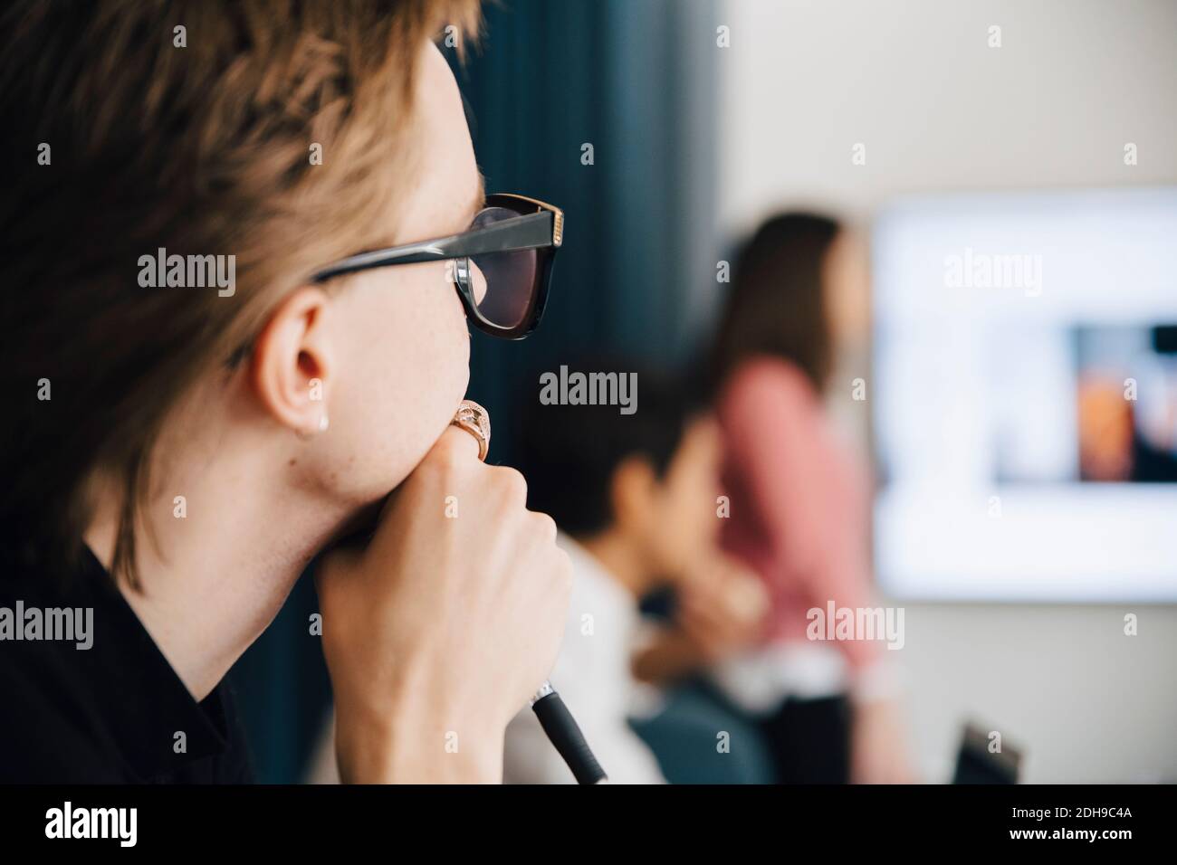 Young genderblend professional in board room during meeting Stock Photo