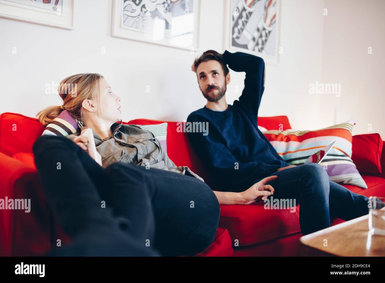 Couple talking while relaxing on sofa at home Stock Photo