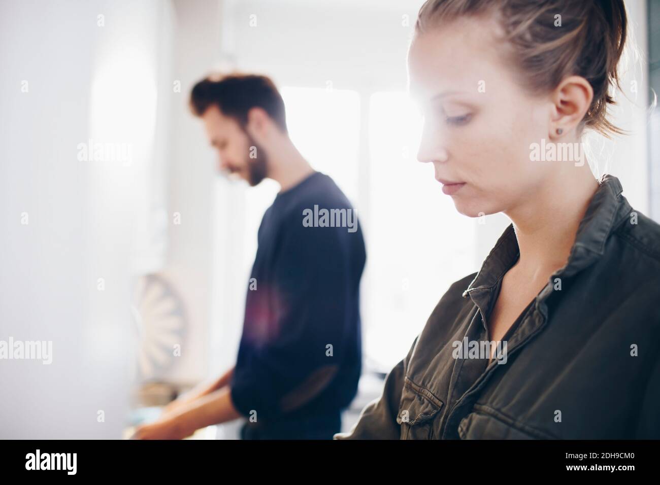 Side view of couple working in kitchen at home Stock Photo