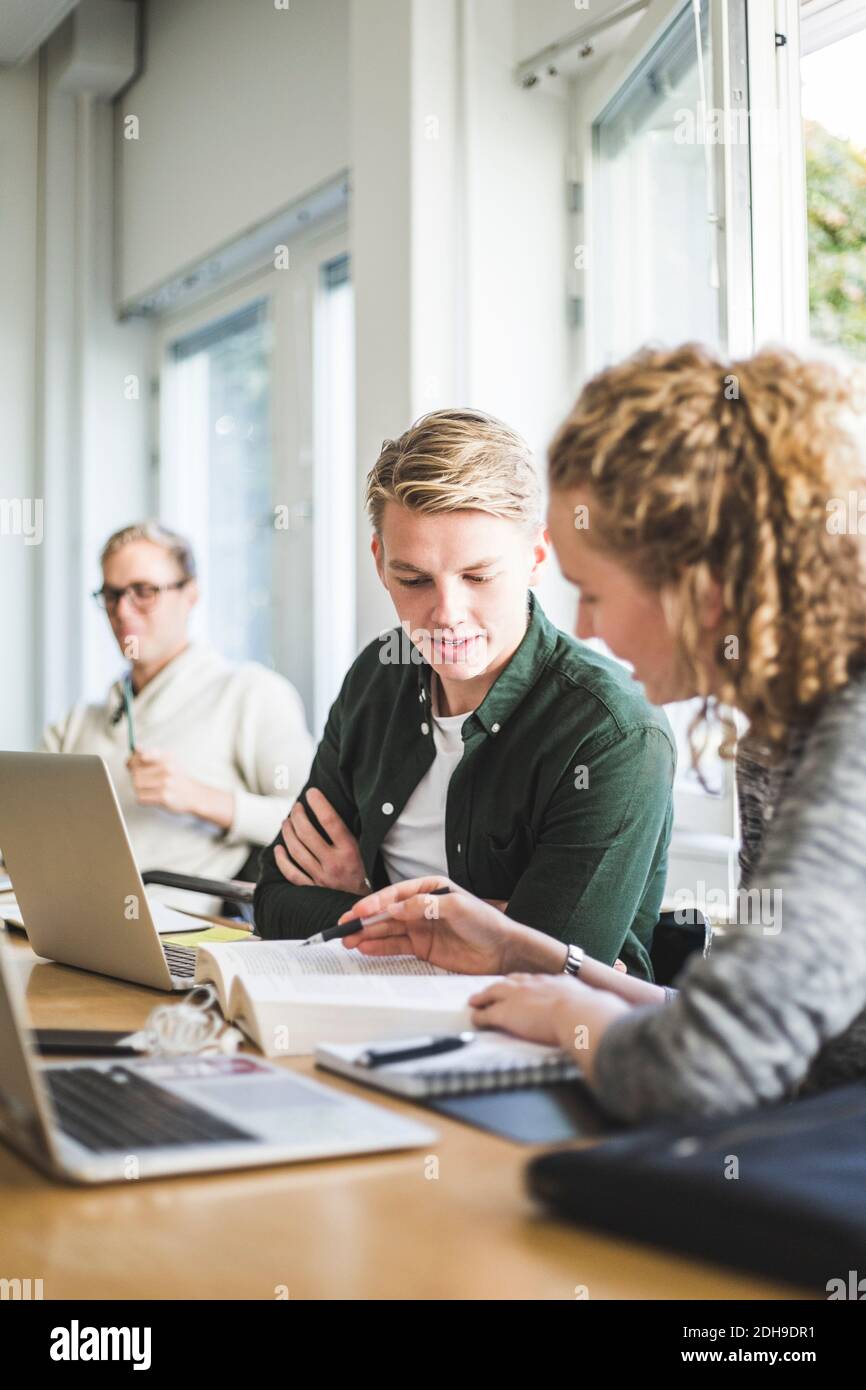 Male and female students studying in classroom at university Stock Photo