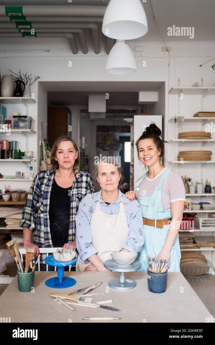 Portrait of female potters by workbench at ceramics store Stock Photo