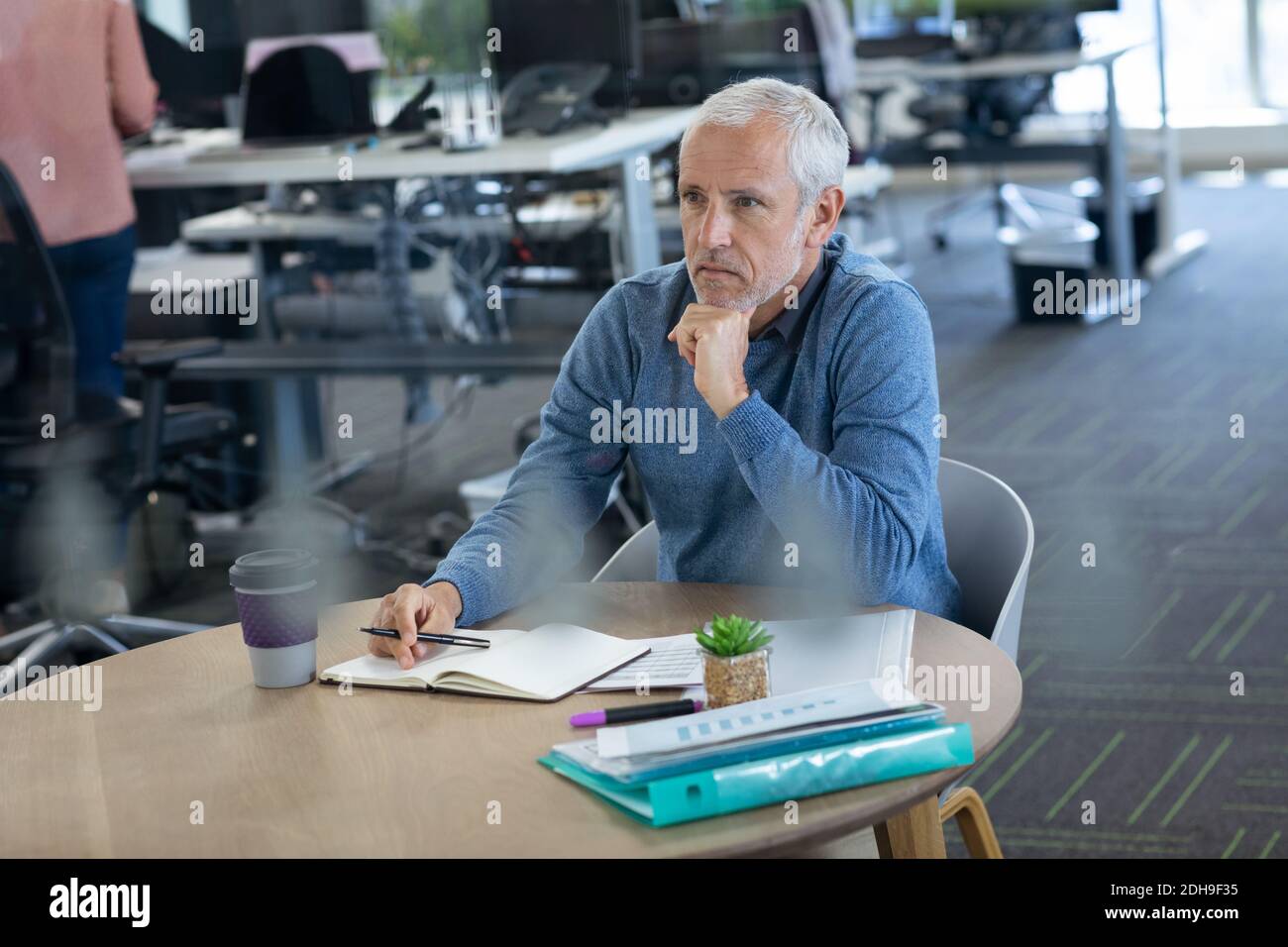 Thoughtful senior businessman taking notes at office Stock Photo