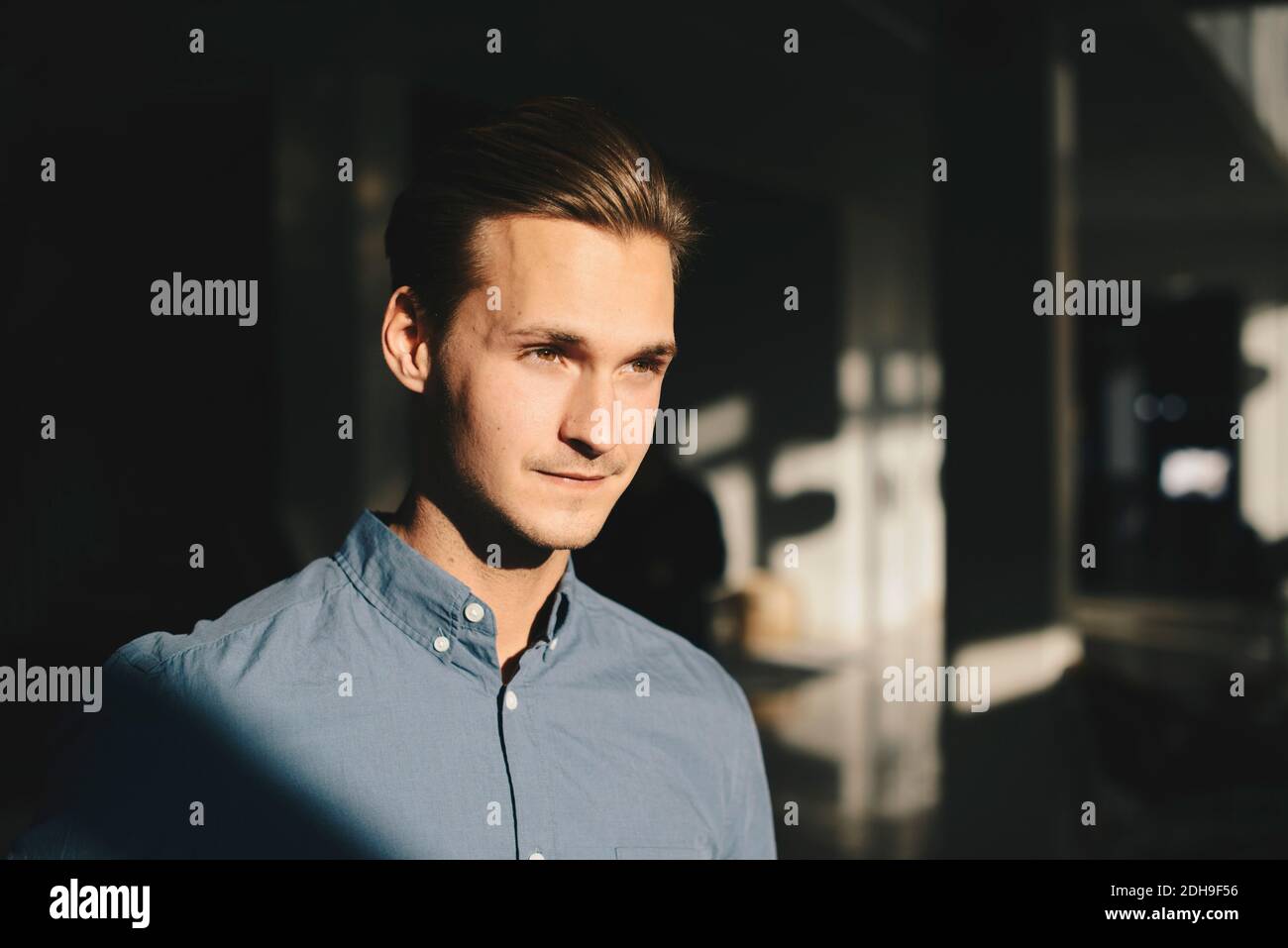 Thoughtful businessman in brightly lit office Stock Photo
