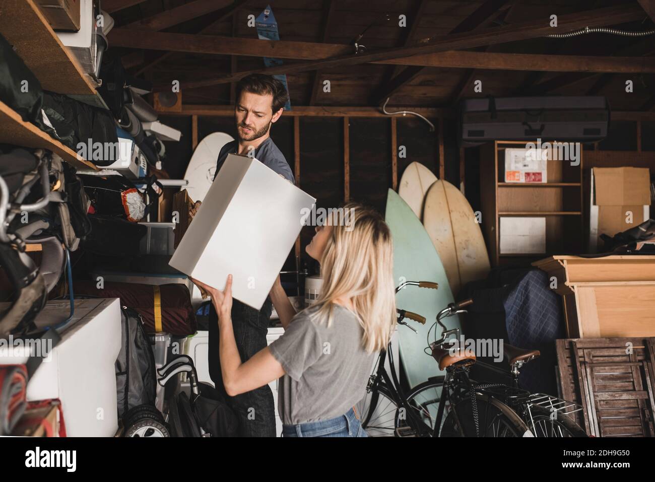 Mid adult couple arranging box in storage room Stock Photo - Alamy