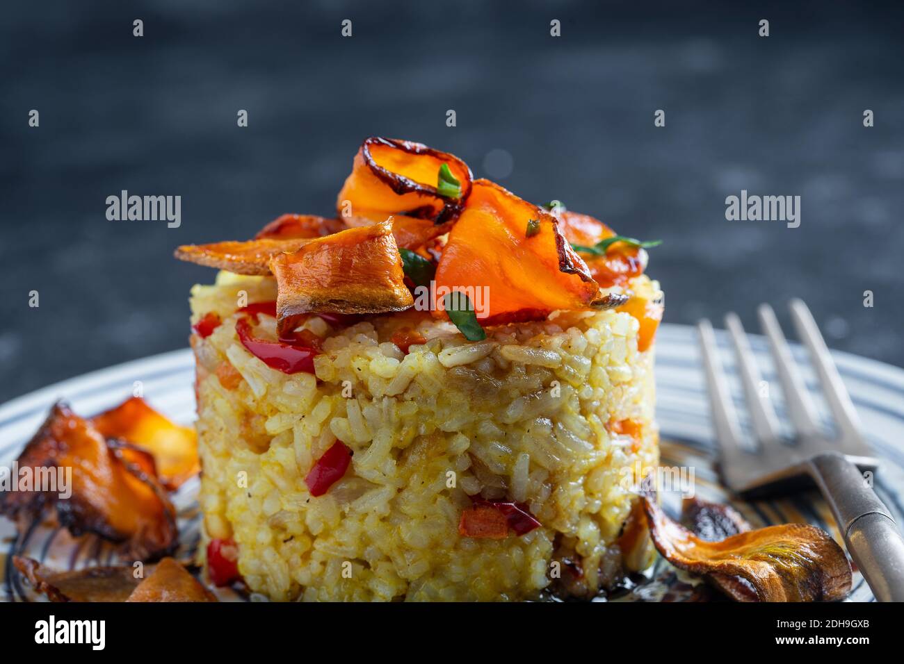 Boiled rice with fried red peppers, carrots and onions, close up. Food
