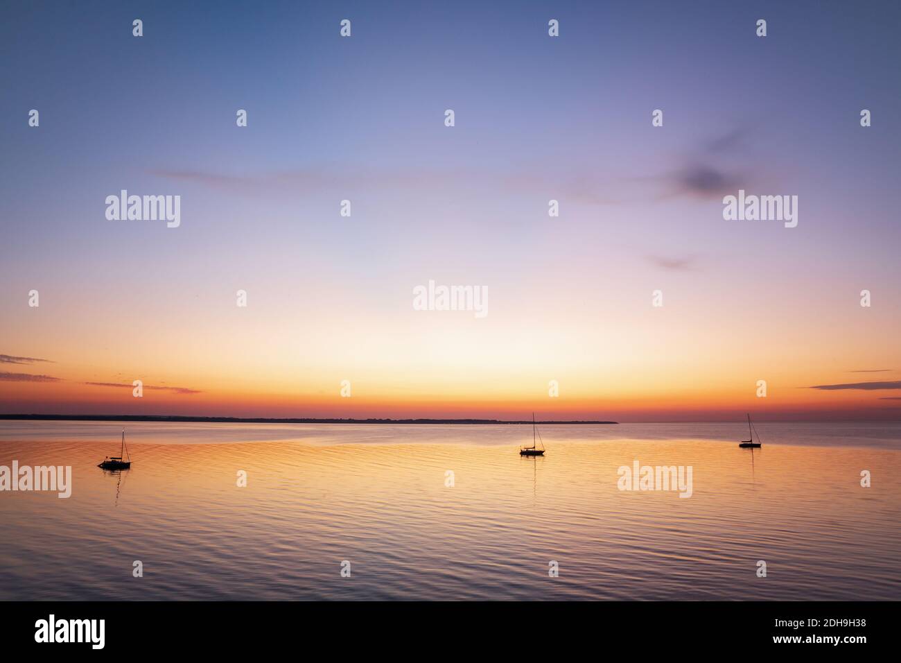 Boats anchored in a peaceful bay after sunset at the Baltic Sea Stock Photo