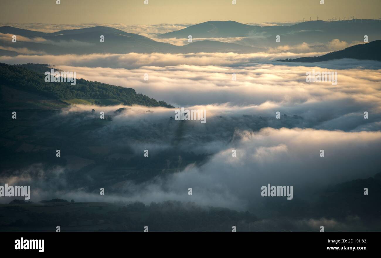 Misty sunrise alternating forested mountains and green valleys in the lands of Samos on the Camino de Santiago in Galicia Stock Photo