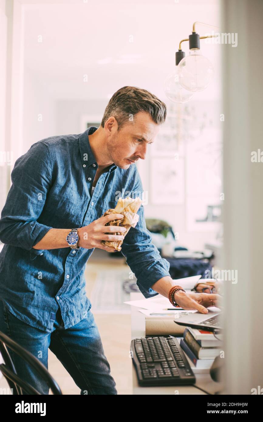 Businessman having lunch working from home Stock Photo