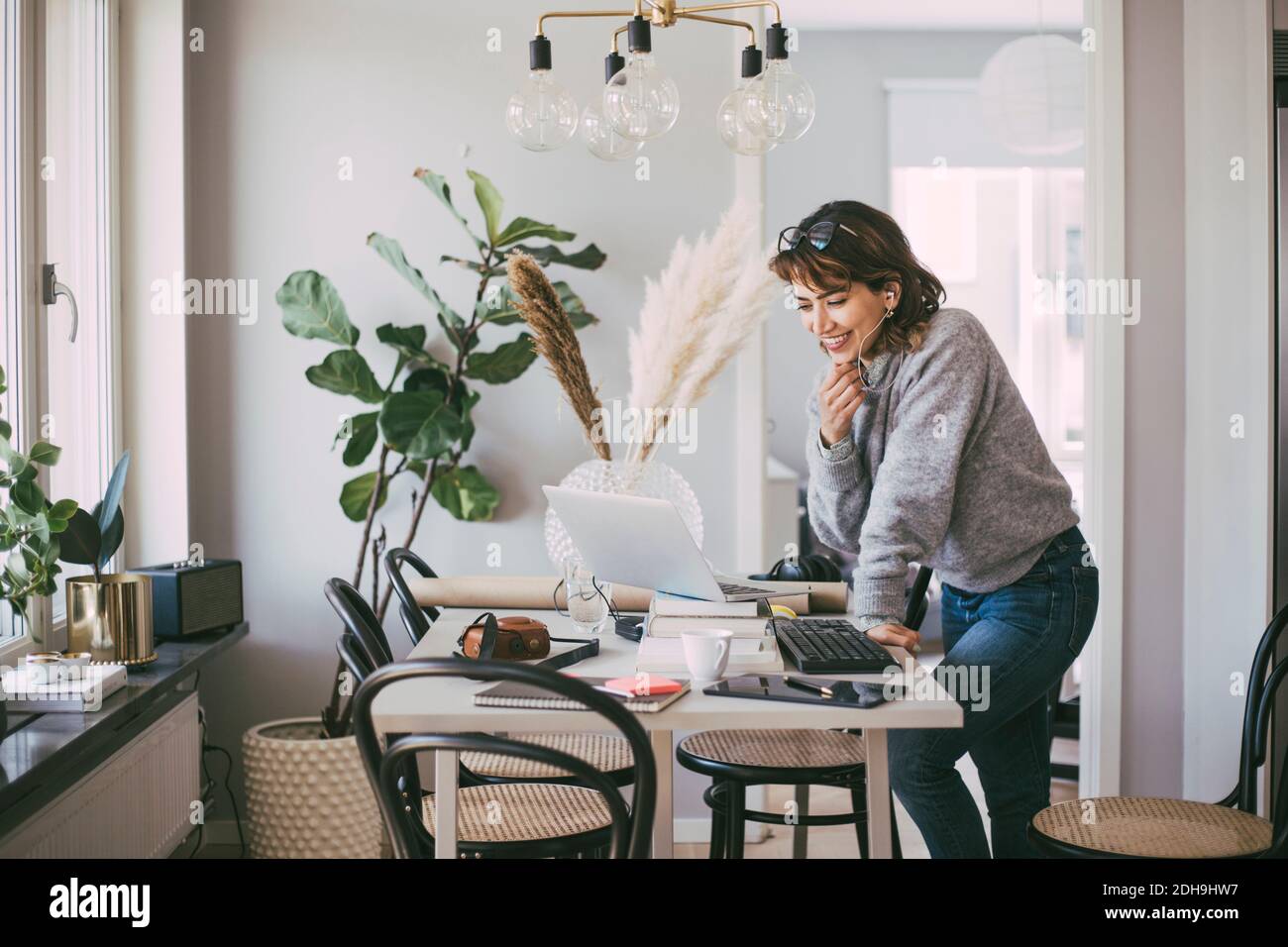 Smiling woman talking on the phone working at home Stock Photo