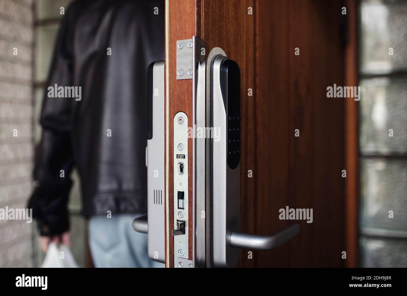 Close-up of modern lock on door with senior man in background Stock Photo
