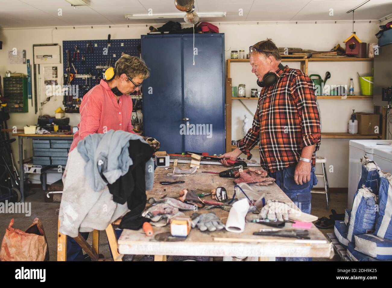 Senior couple standing at workbench in workshop Stock Photo