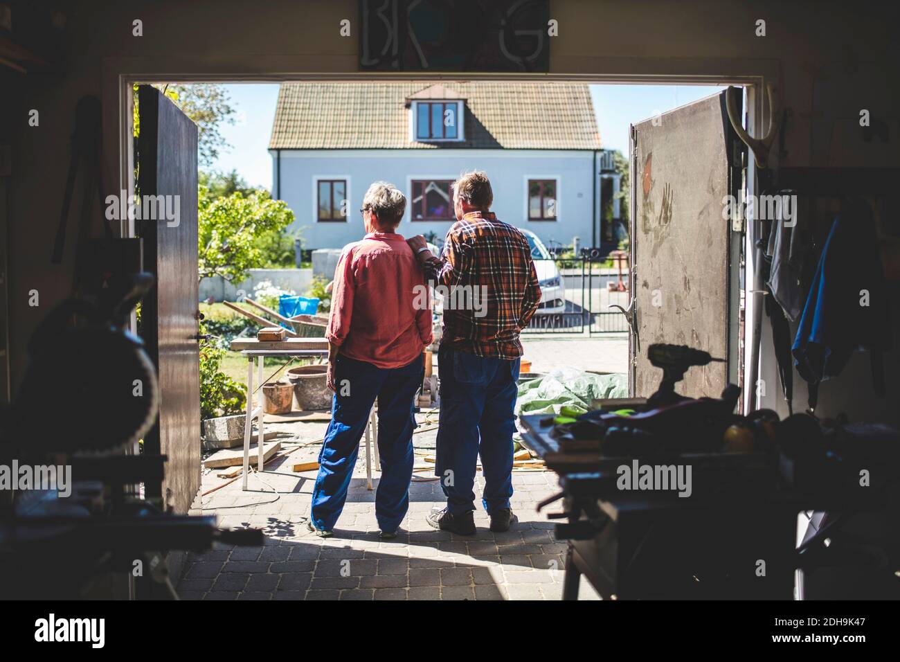 Senior couple looking at yard while standing in workshop Stock Photo