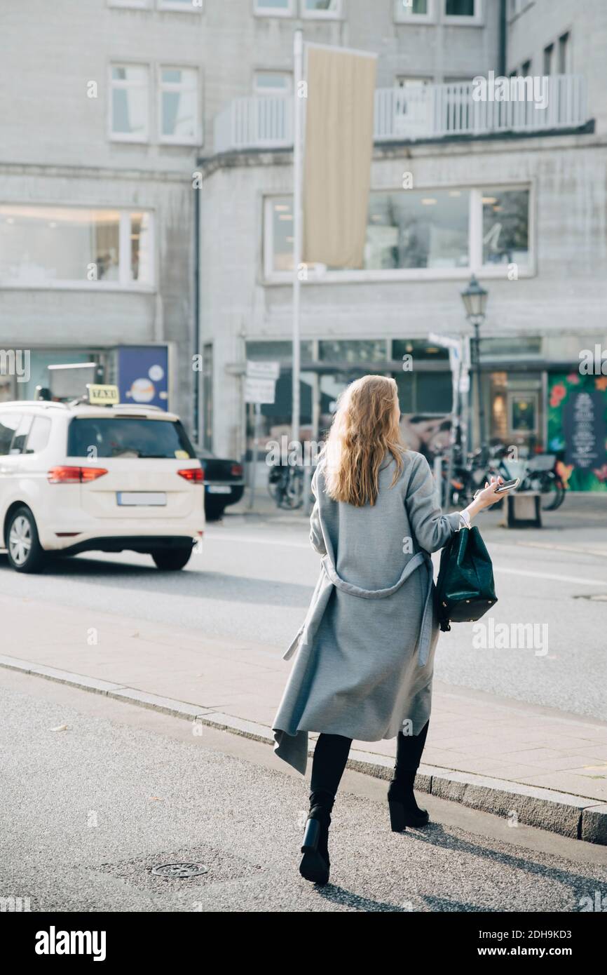 Rear view of female entrepreneur walking in city Stock Photo - Alamy