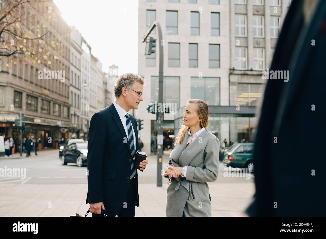 Business colleagues talking while standing in city Stock Photo