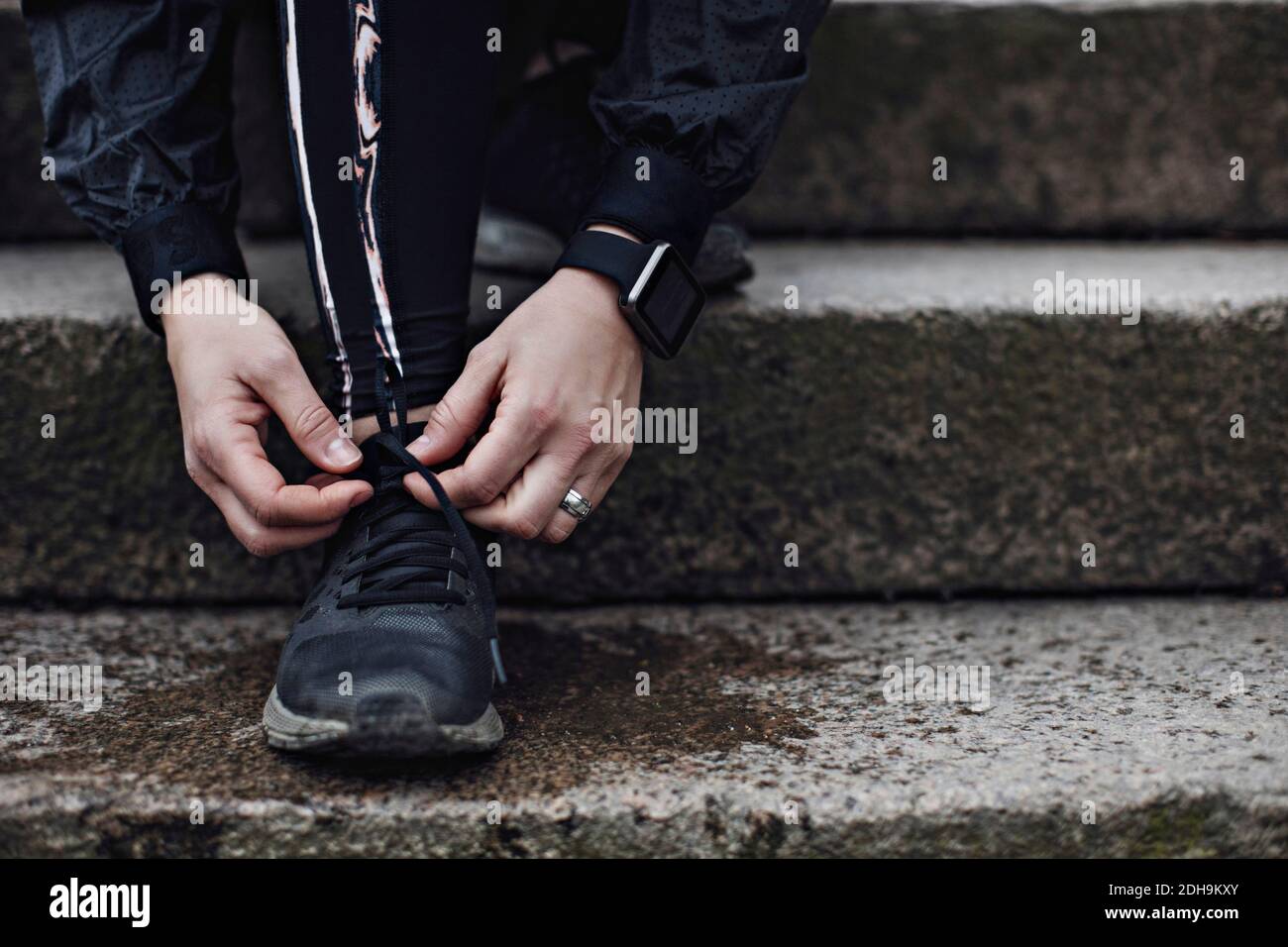 Low section of young woman tying shoelace on steps Stock Photo - Alamy