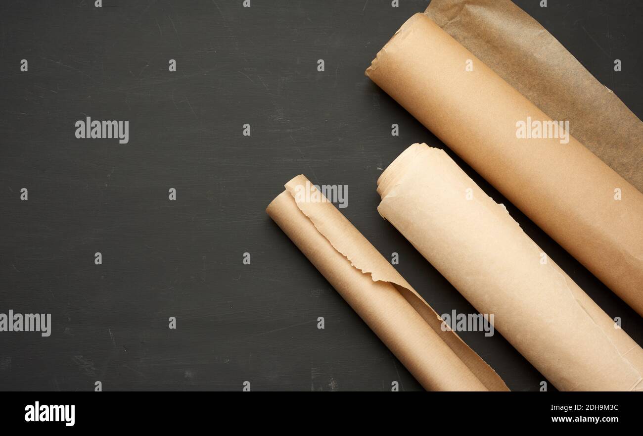 Rolls of brown parchment paper on a wooden background Stock Photo