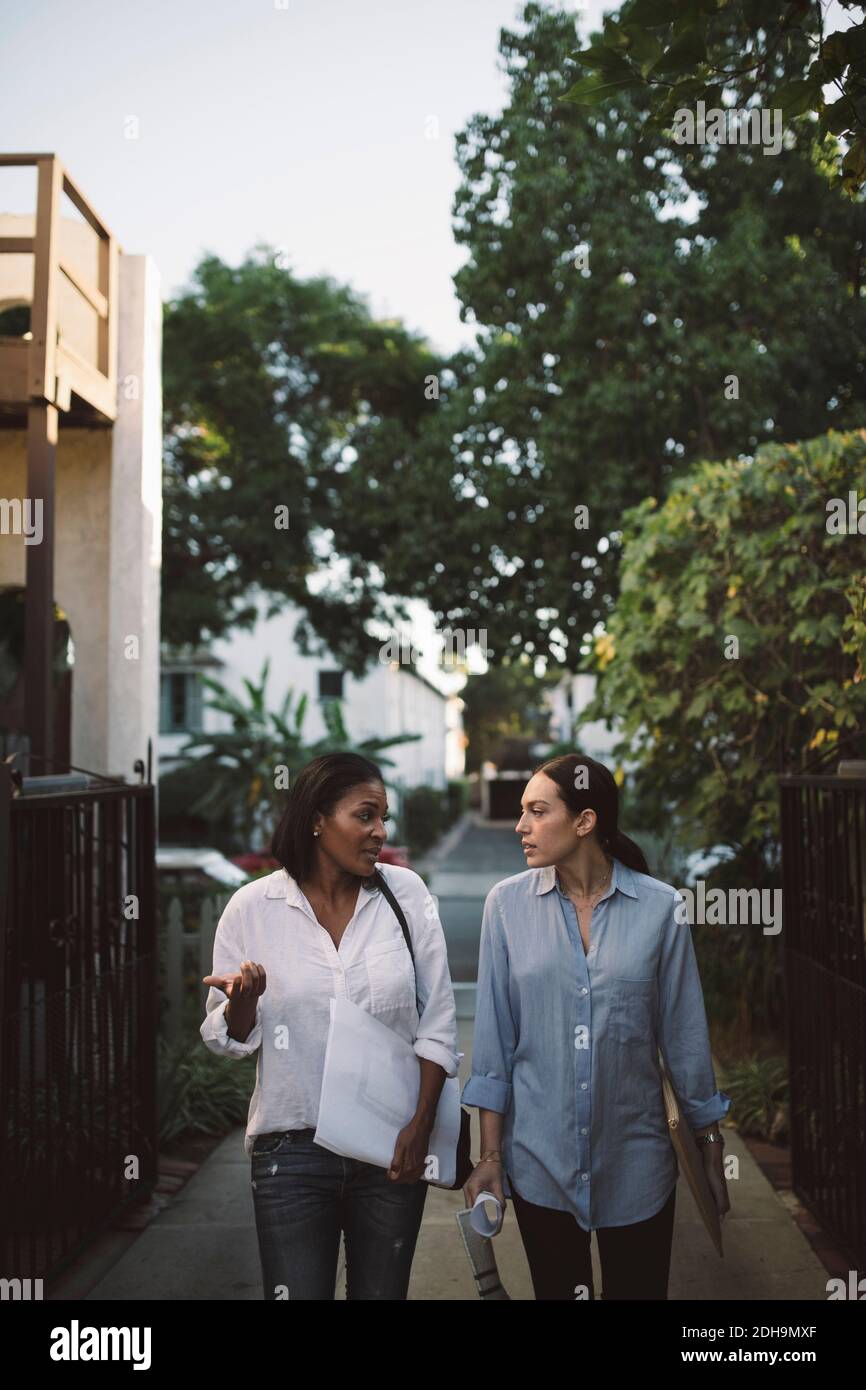 Female designers discussing while walking on footpath Stock Photo