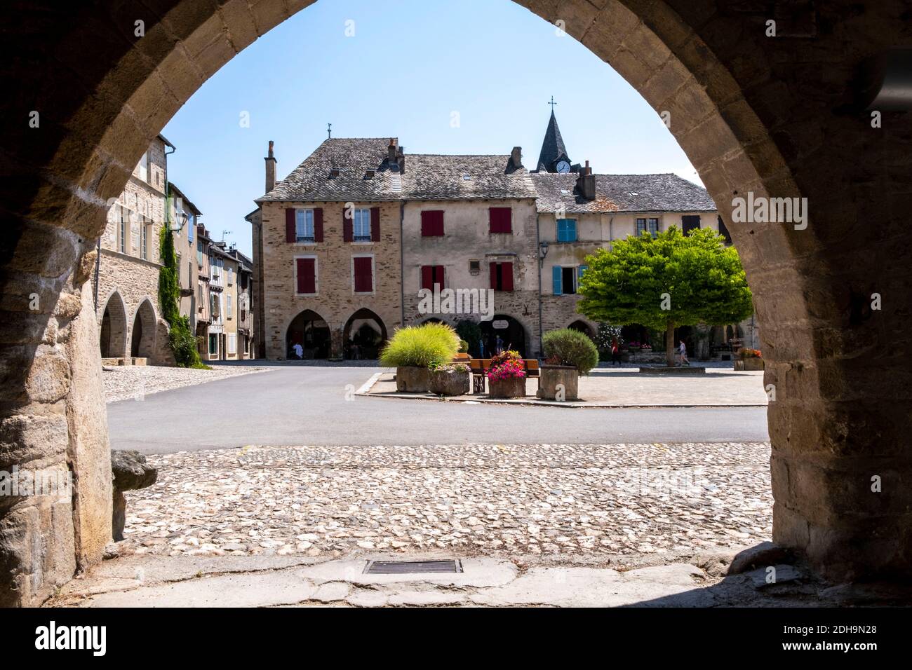 Sauveterre-de-Rouergue (south of France): traditional houses in “place des Arcades” square. Facades of traditional houses and arches of the former Roy Stock Photo