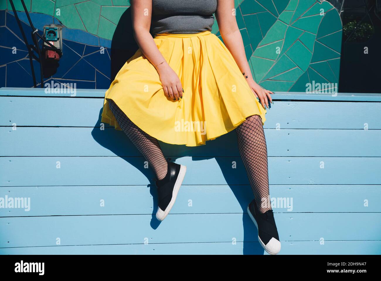 Young woman sitting wall city hi-res stock photography and images - Alamy