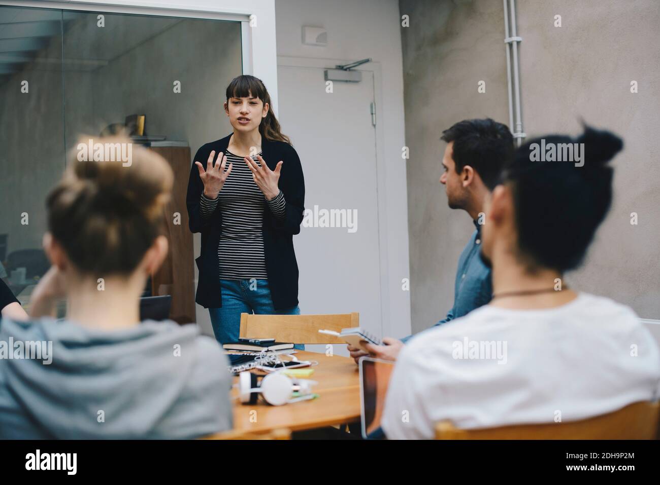 Female computer programmer giving presentation to colleagues in office Stock Photo