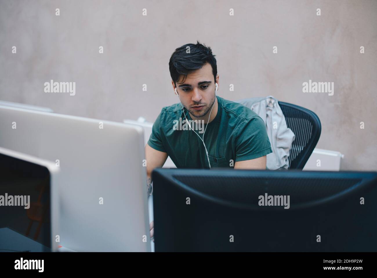 Male computer programmer using desktop PC in office Stock Photo