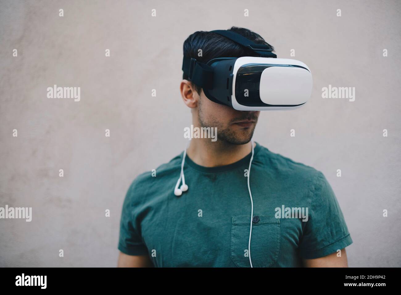 Computer programmer using VR glasses against beige wall in office Stock Photo