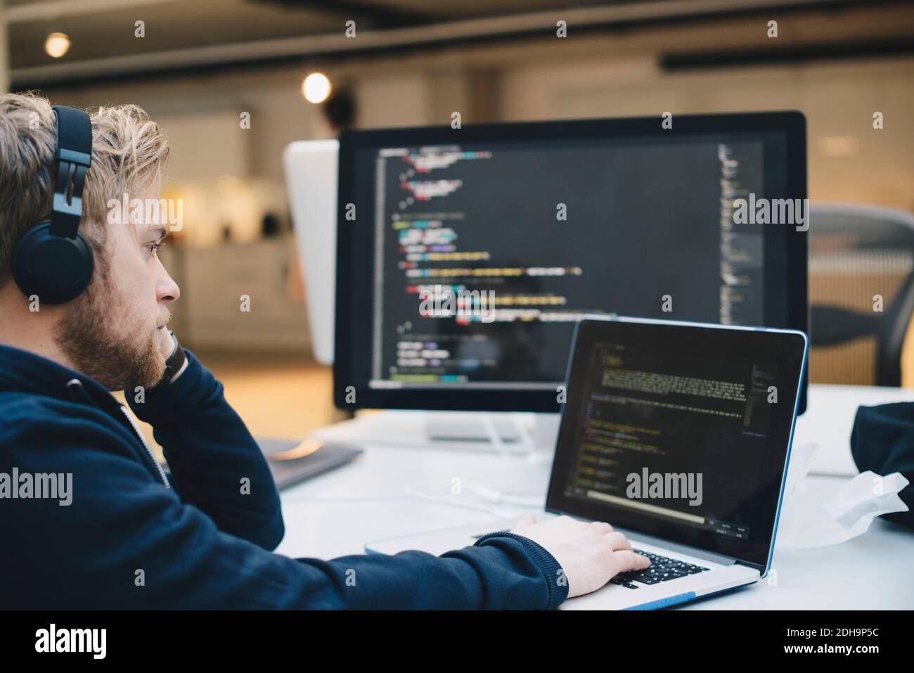 Side view of businessman programming on laptop at creative office Stock ...