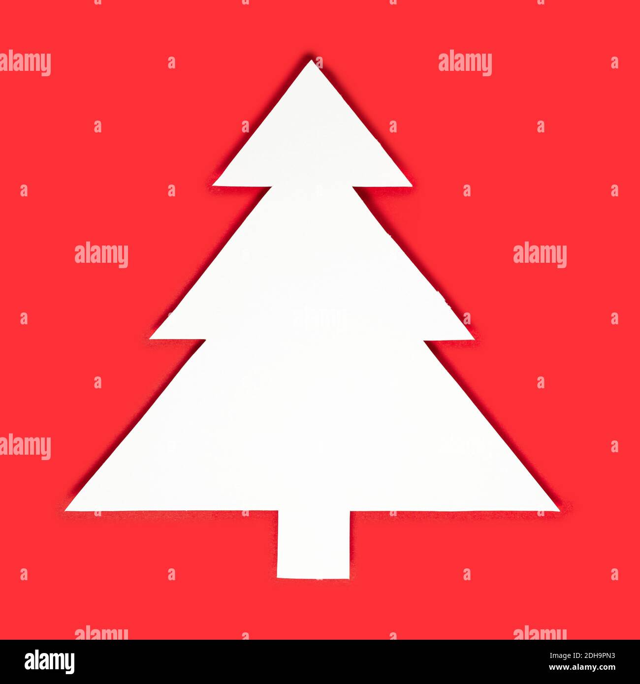 Paper cut Christmas trees on a red background. Creative design of