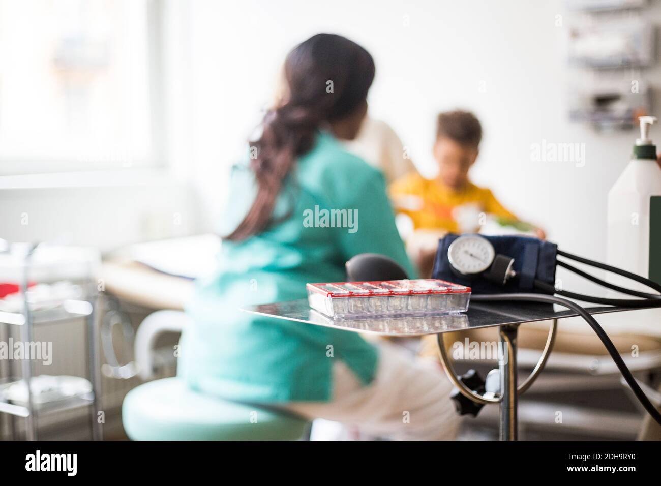 Rear view of female pediatrician with boy in clinic Stock Photo