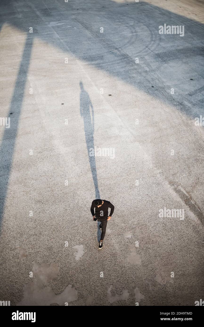 High angle view of man using smart phone while walking on footpath Stock Photo
