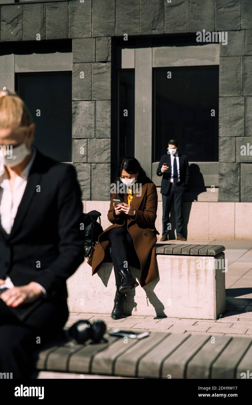 Business people with face masks keeping social distance Stock Photo