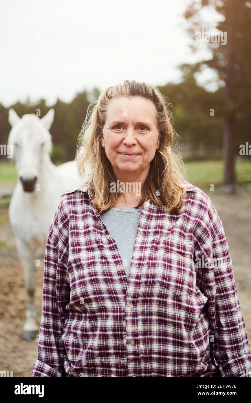 Portrait of female farmer standing on field Stock Photo