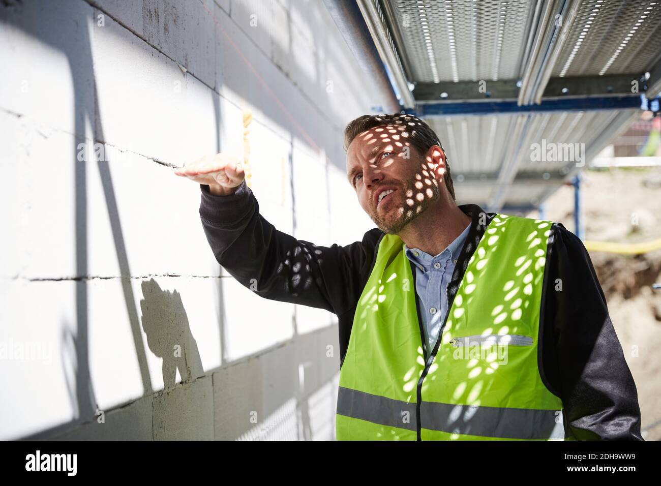 Architect gesturing while analyzing at construction site Stock Photo