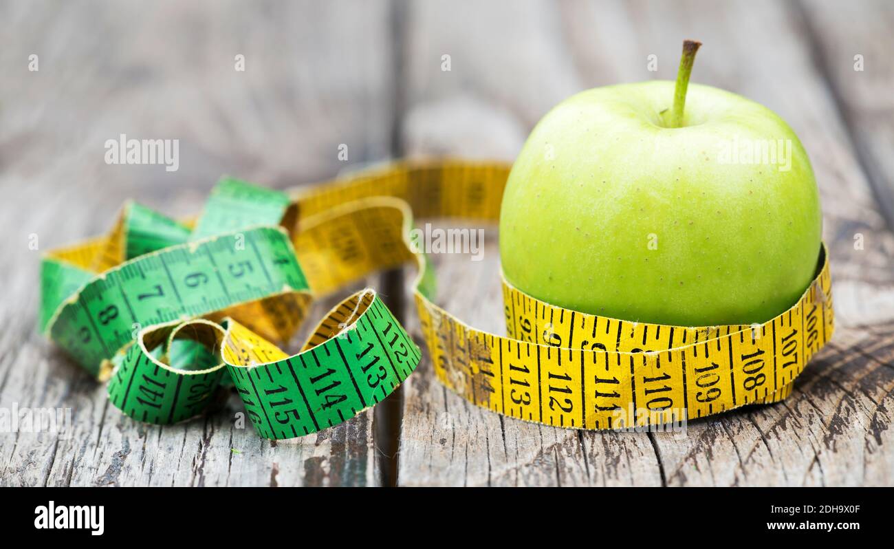 Weight loss, diet, diabetes concept green apple with an old tape