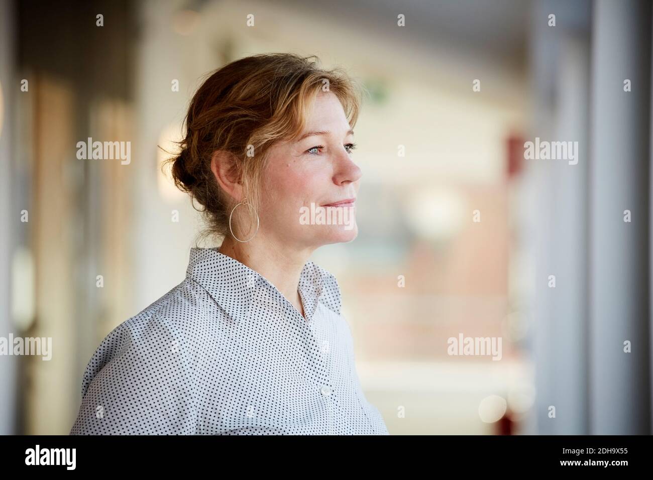 Confident female entrepreneur looking away while standing at workplace Stock Photo