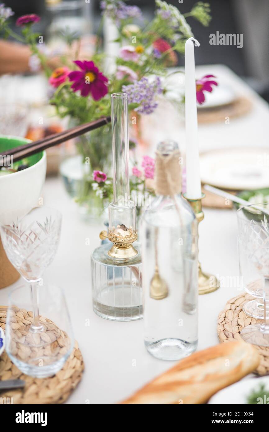 Glassware arranged for dinner on table during party at building terrace Stock Photo